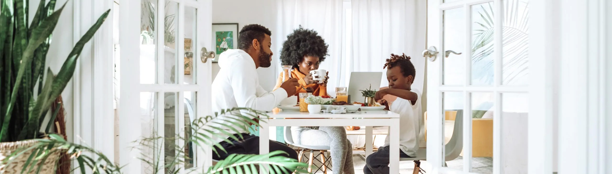 Family of three enjoying breakfast in the morning at the dining table.