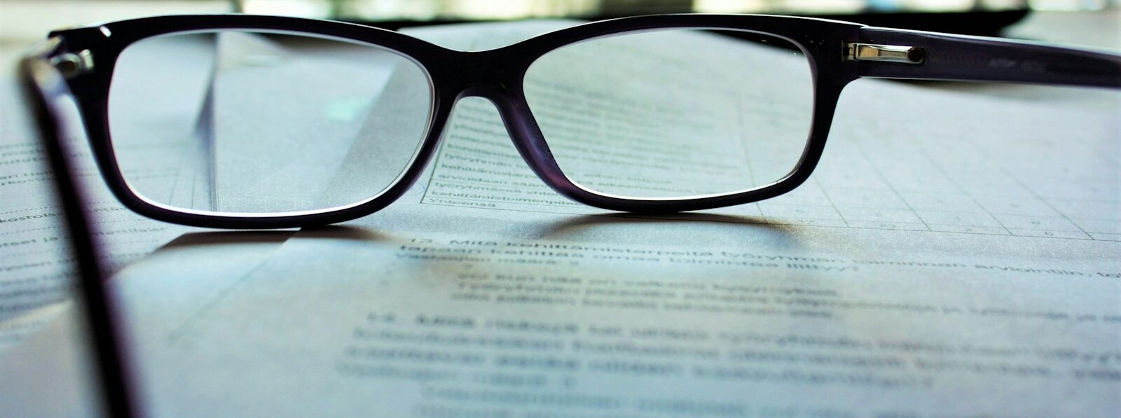 black-framed eyeglasses on white printing paper