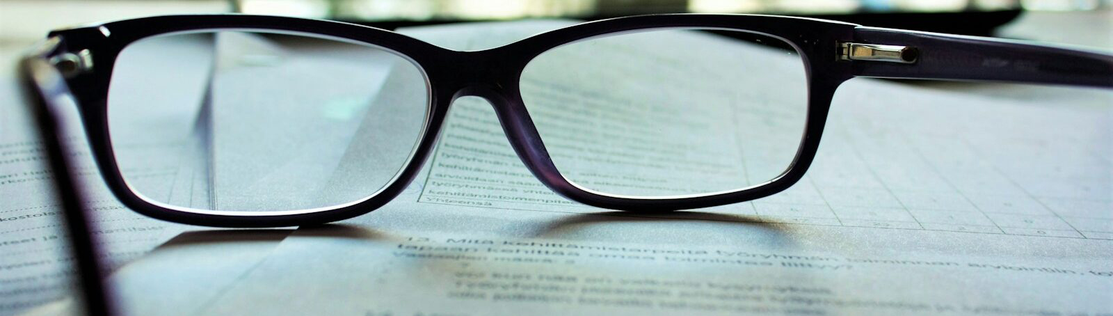 Eyeglasses resting on stack of papers